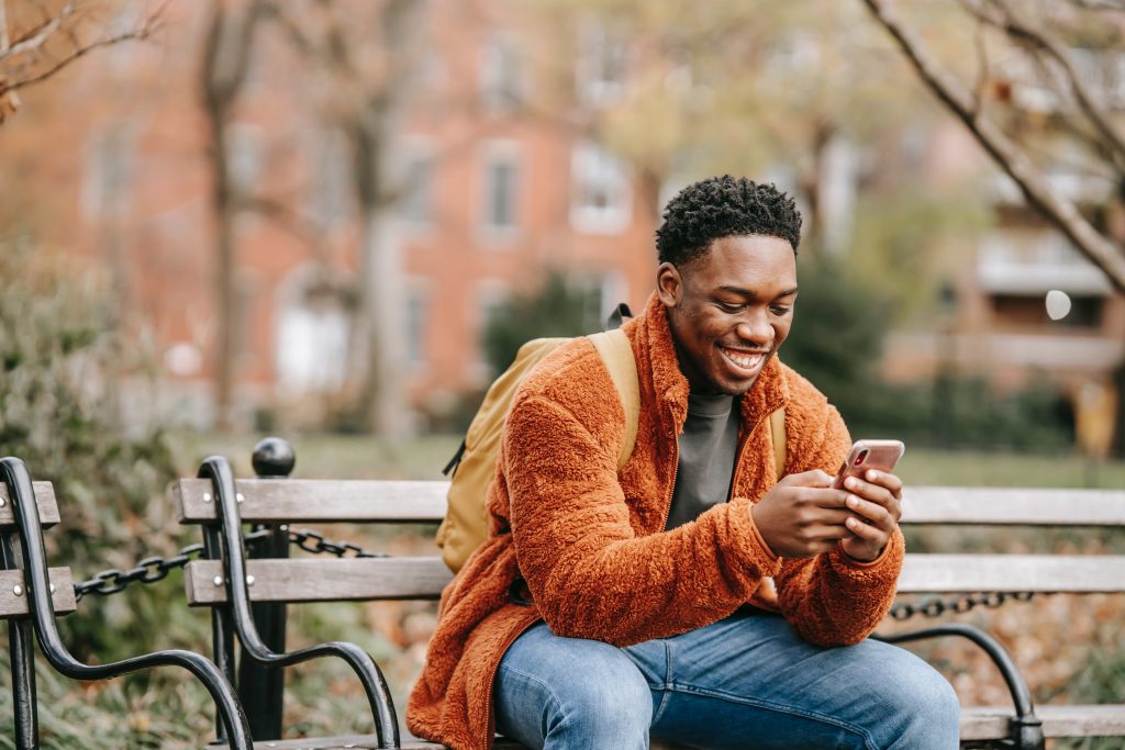 man looking at his phone smiling