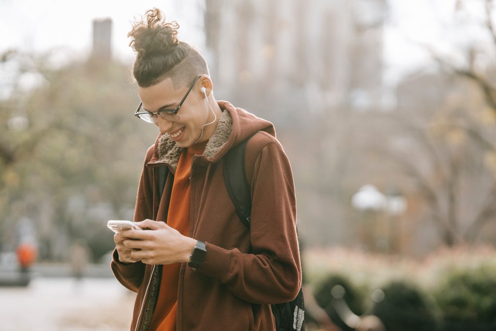 man looking and smiling at phone