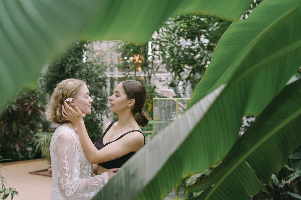 two women flirting under palm trees